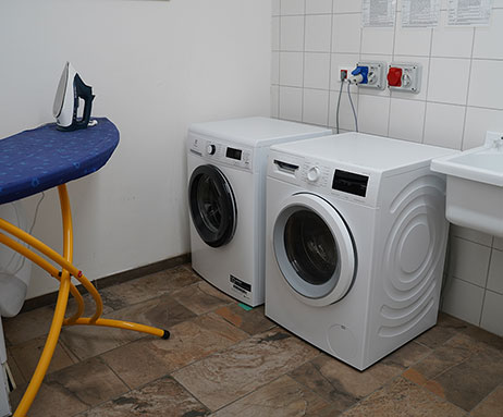 Lavanderia con lavatrice, asciugatrice e ferro da stiro